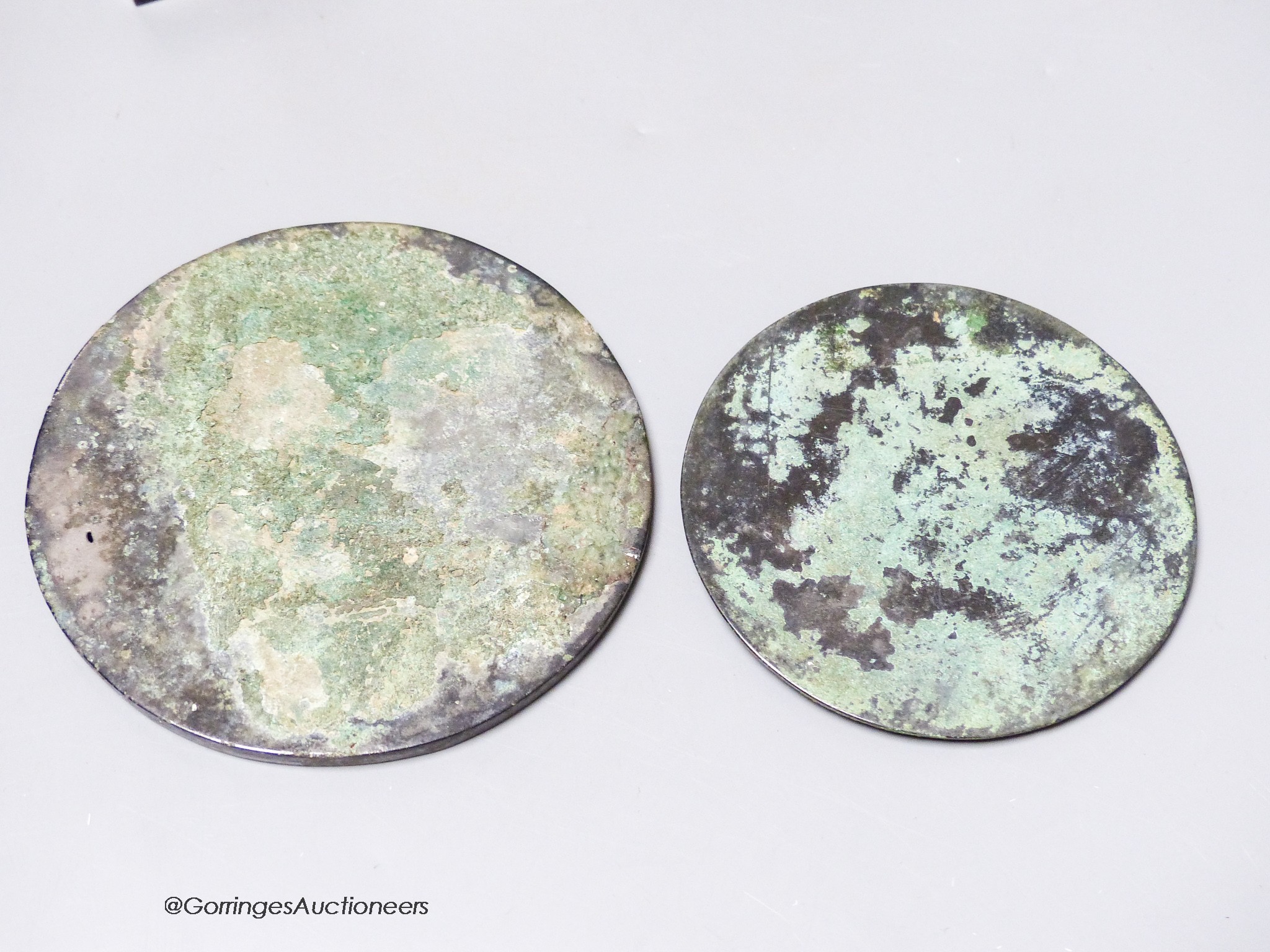 Two Chinese archaic bronze circular mirrors, etc., largest 11cm